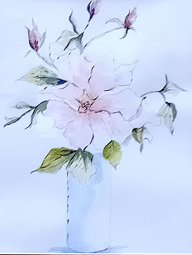 Pink rose with buds in a clear vase.