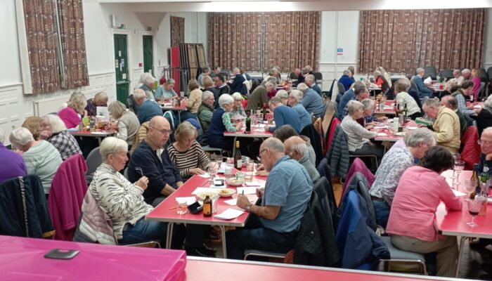 Hall full of players with heads down at a quiz event.