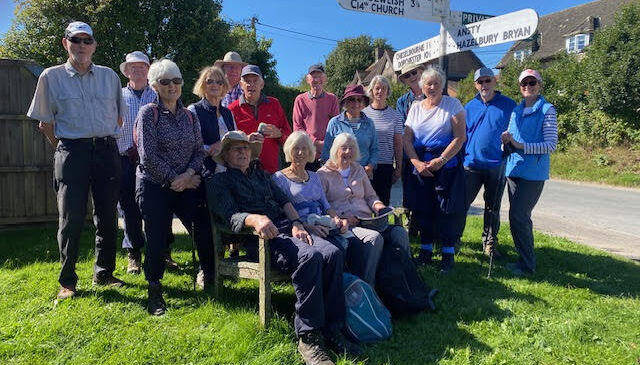 Walking group 5 pausing at signpost for a group photo.